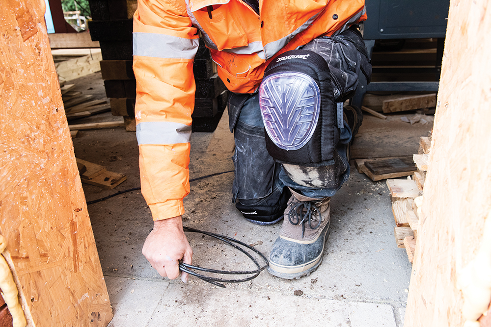 Person wearing Silverline hard cap gel knee pads while kneeling on a construction site.
