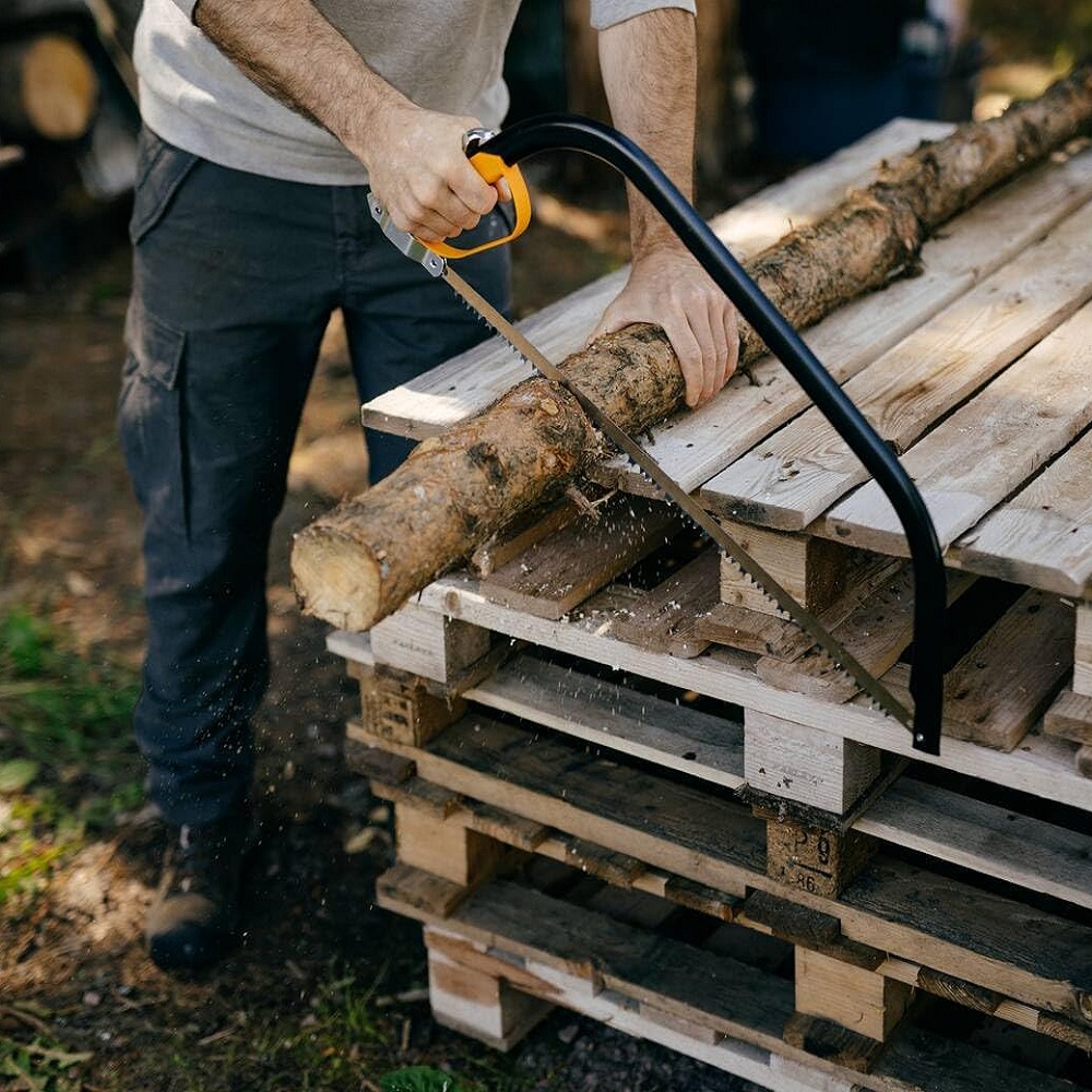 Fiskars 21-Inch Tree Pruning Bowsaw cutting log on pile of pallets