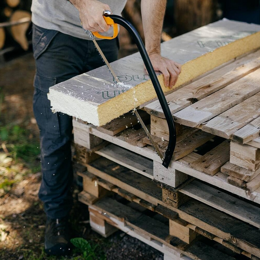Fiskars 21-Inch Tree Pruning Bowsaw cutting insulation board on pile of pallets