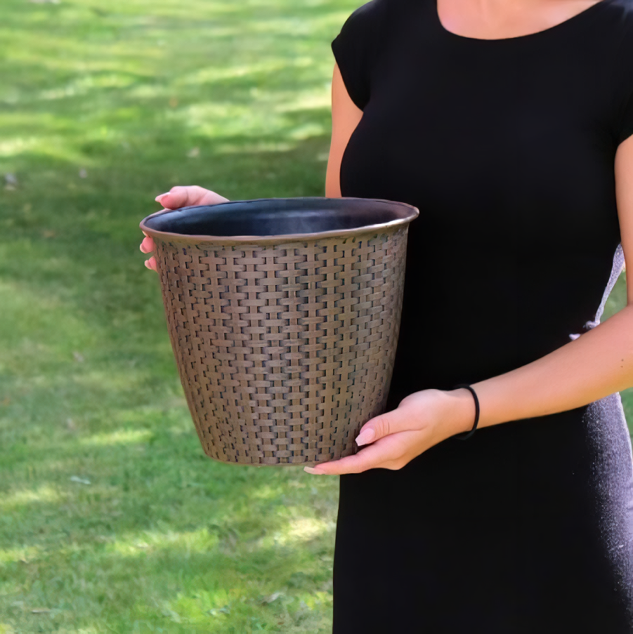 Person holding a 13.5 inch interwoven rattan garden flower pot on a grassy background.