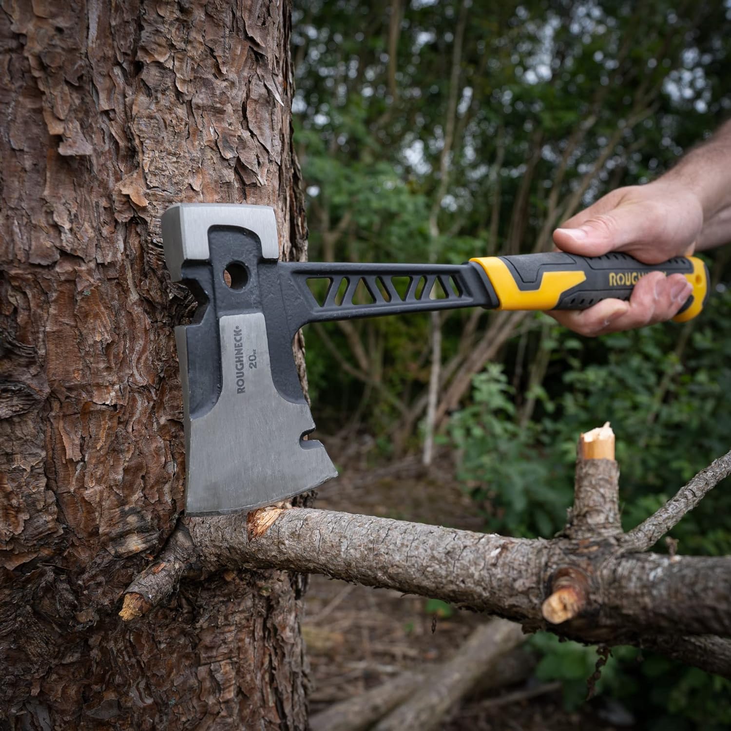 Hand holding a Roughneck Gorilla V Series Utility Hand Axe cutting a tree branch.