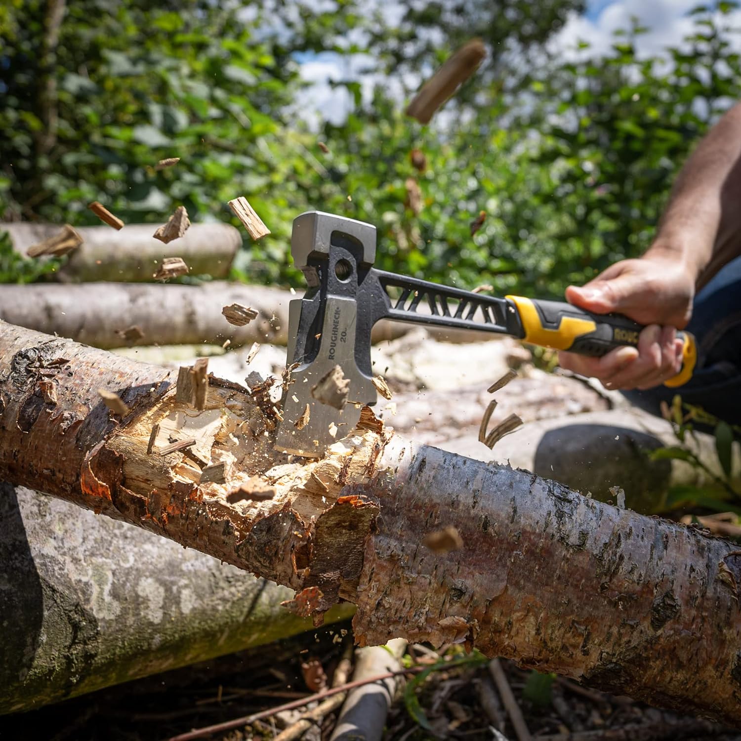 Hand axe chopping a tree branch with wood chips flying.