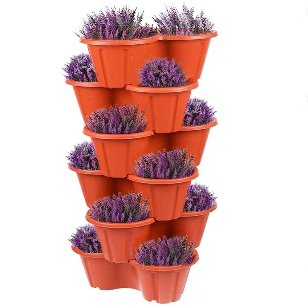 Stacked orange planter pots filled with purple flowers.