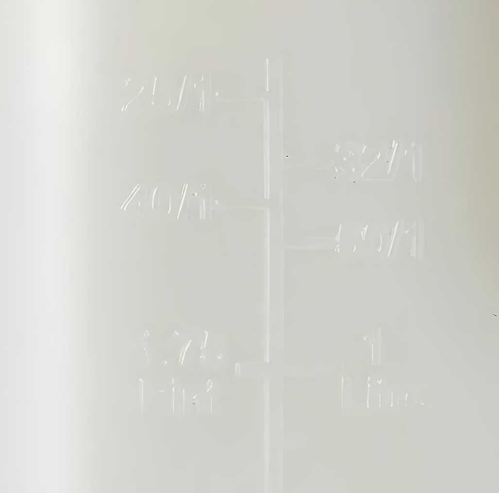 Close-up of a transparent mixing bottle with measurement markings for petrol and oil ratios.
