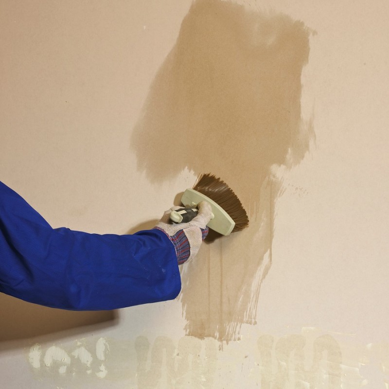 Person applying Bond It Contractors PVA to a wall with a brush.
