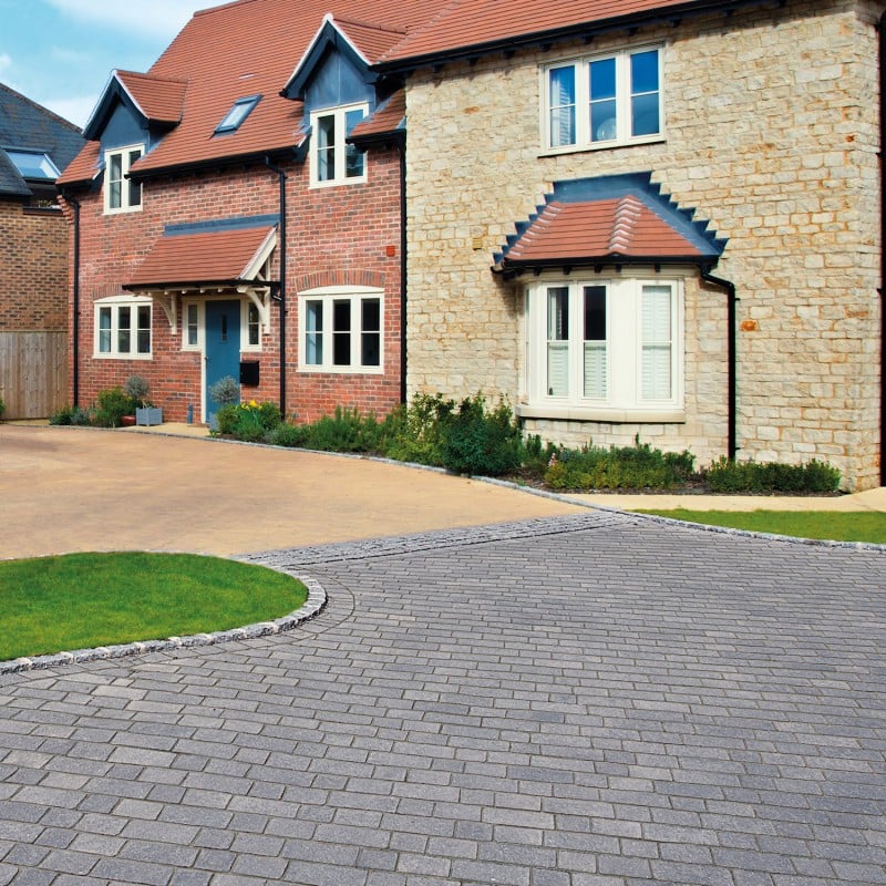 A house with a clean, sealed block paving driveway.