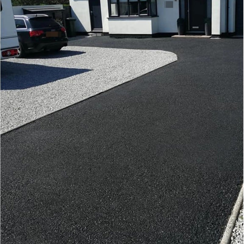 Freshly restored black tarmac driveway next to a gravel path.