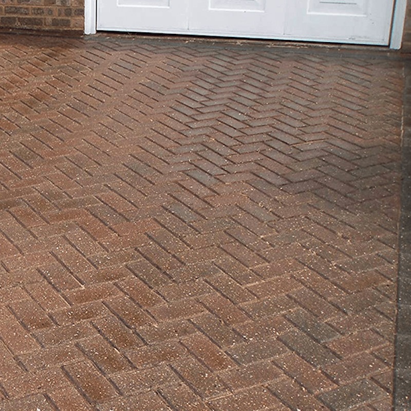 Close-up of a herringbone pattern block paving with a high gloss finish.
