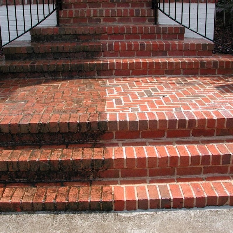 Brick steps showing a comparison between cleaned and moss-covered sections.