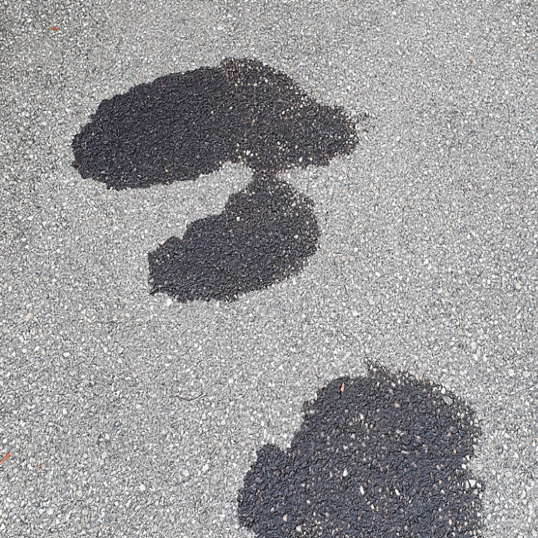 Oil stains on a grey driveway surface.