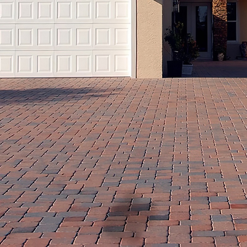 Clean patio and driveway with a white garage door in the background.