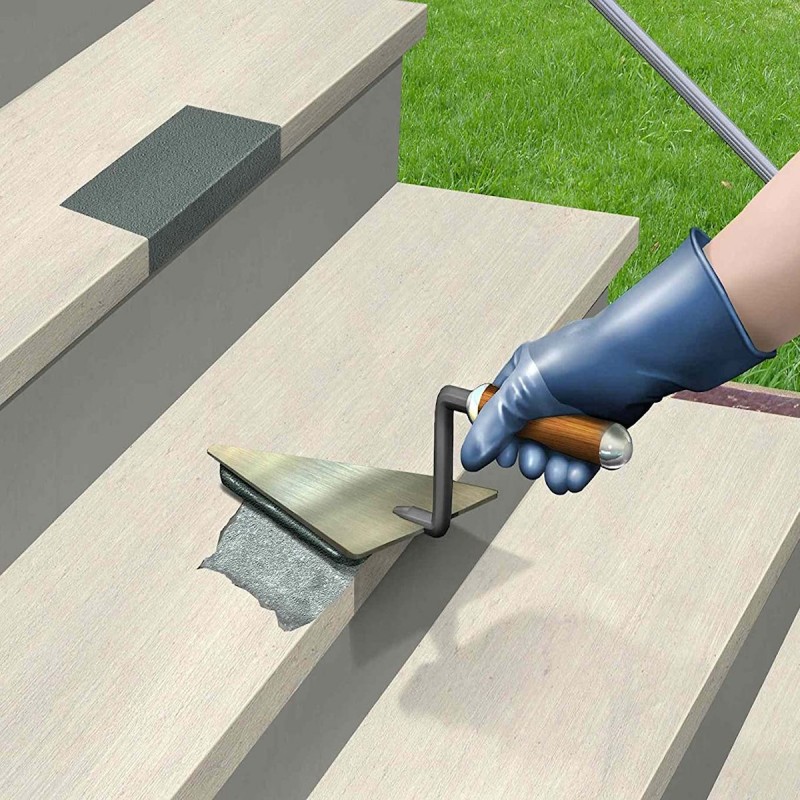 Person applying a bonding agent to concrete steps with a trowel.