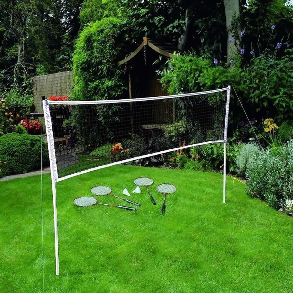 Lush green lawn with a badminton net and rackets set up in a garden.