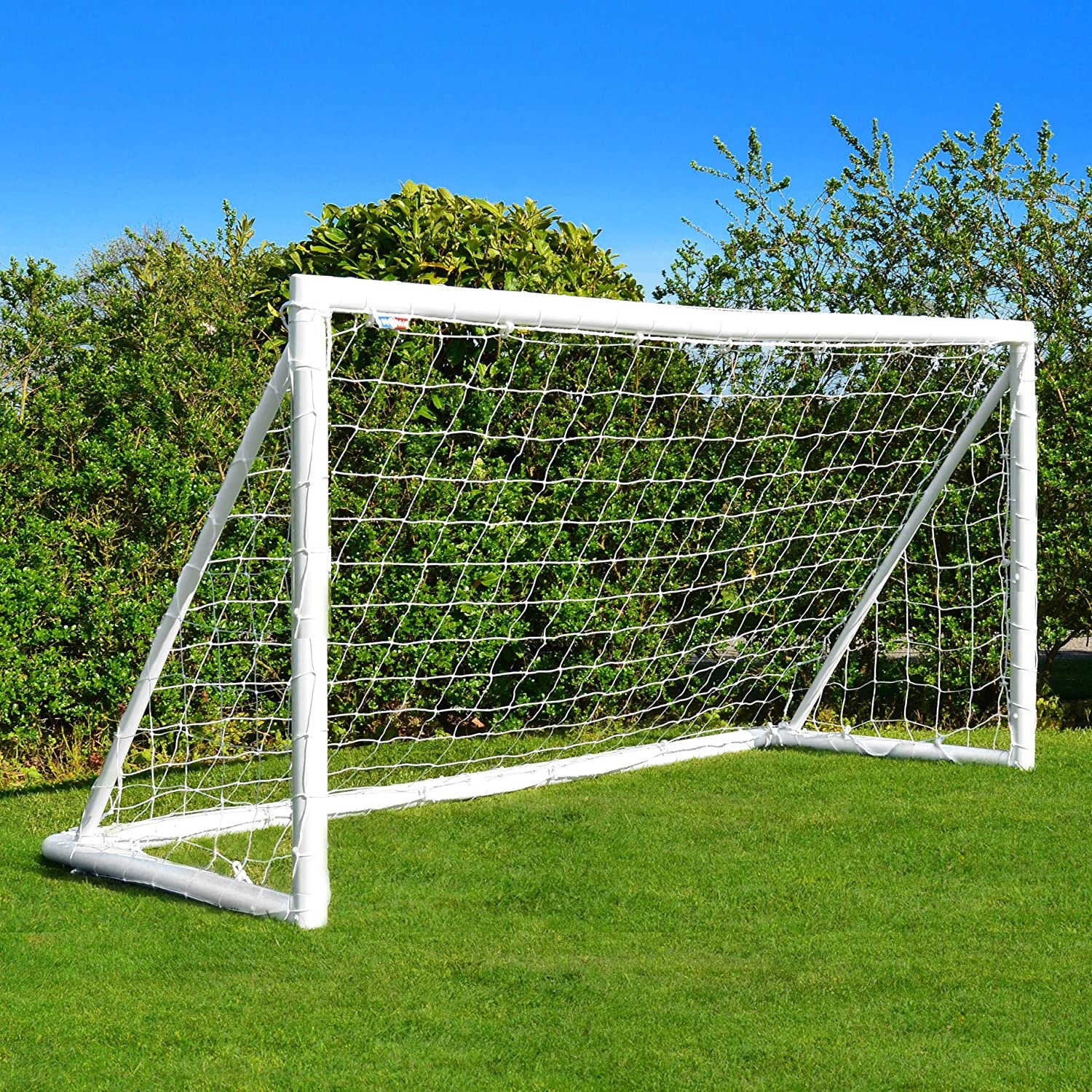 Football goal on a well-maintained lawn with clear blue sky.