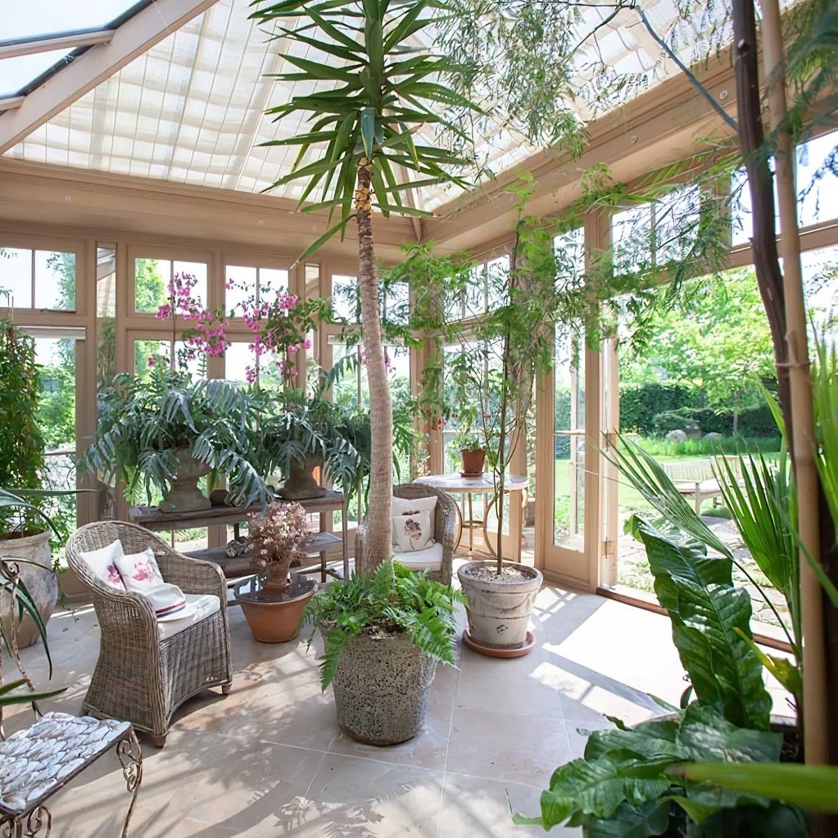 A bright conservatory filled with various house plants and wicker furniture.