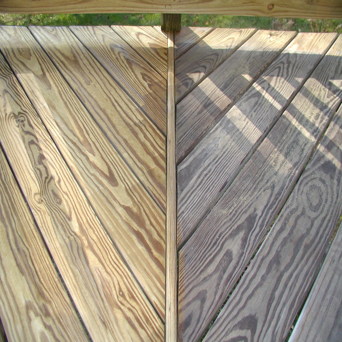 Wooden decking with visible grain patterns and sunlight casting shadows.