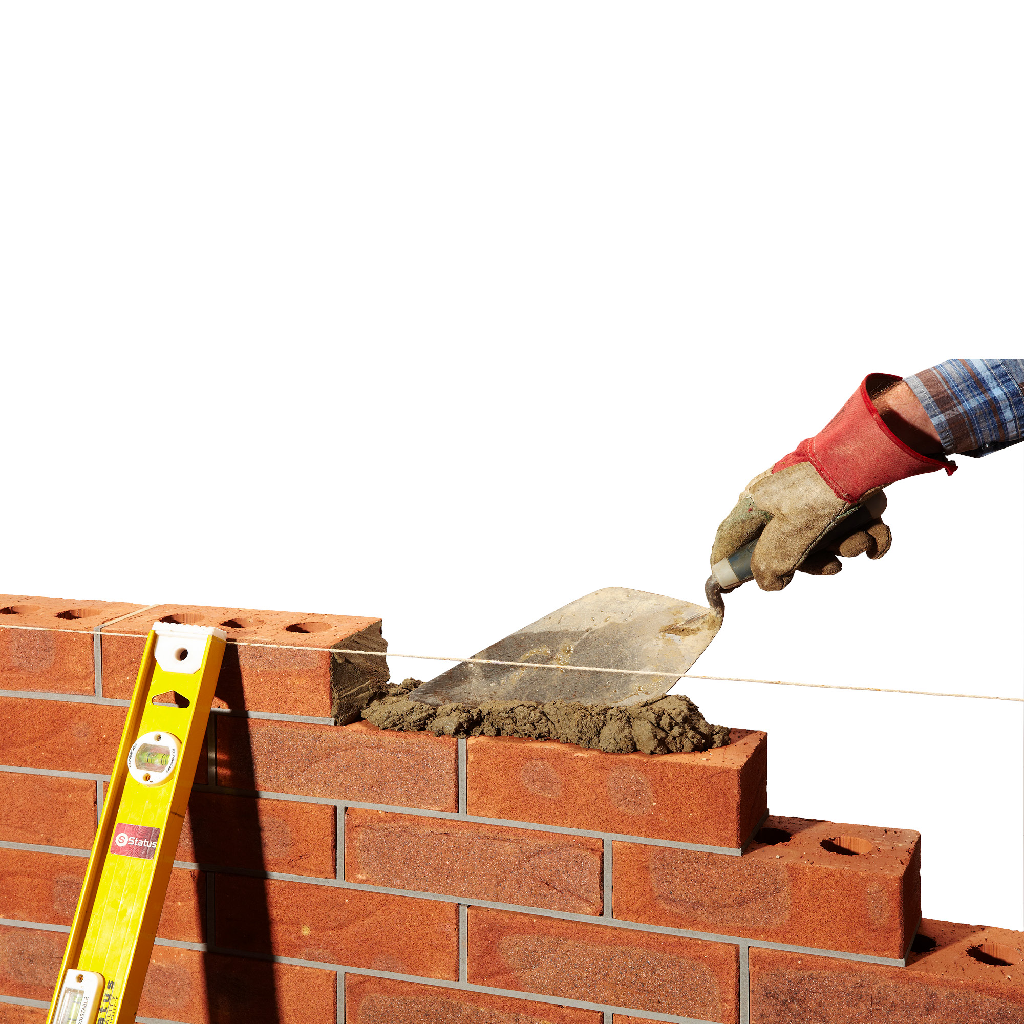 A person applying cement with a trowel on a brick wall, with a yellow level tool resting against the bricks.