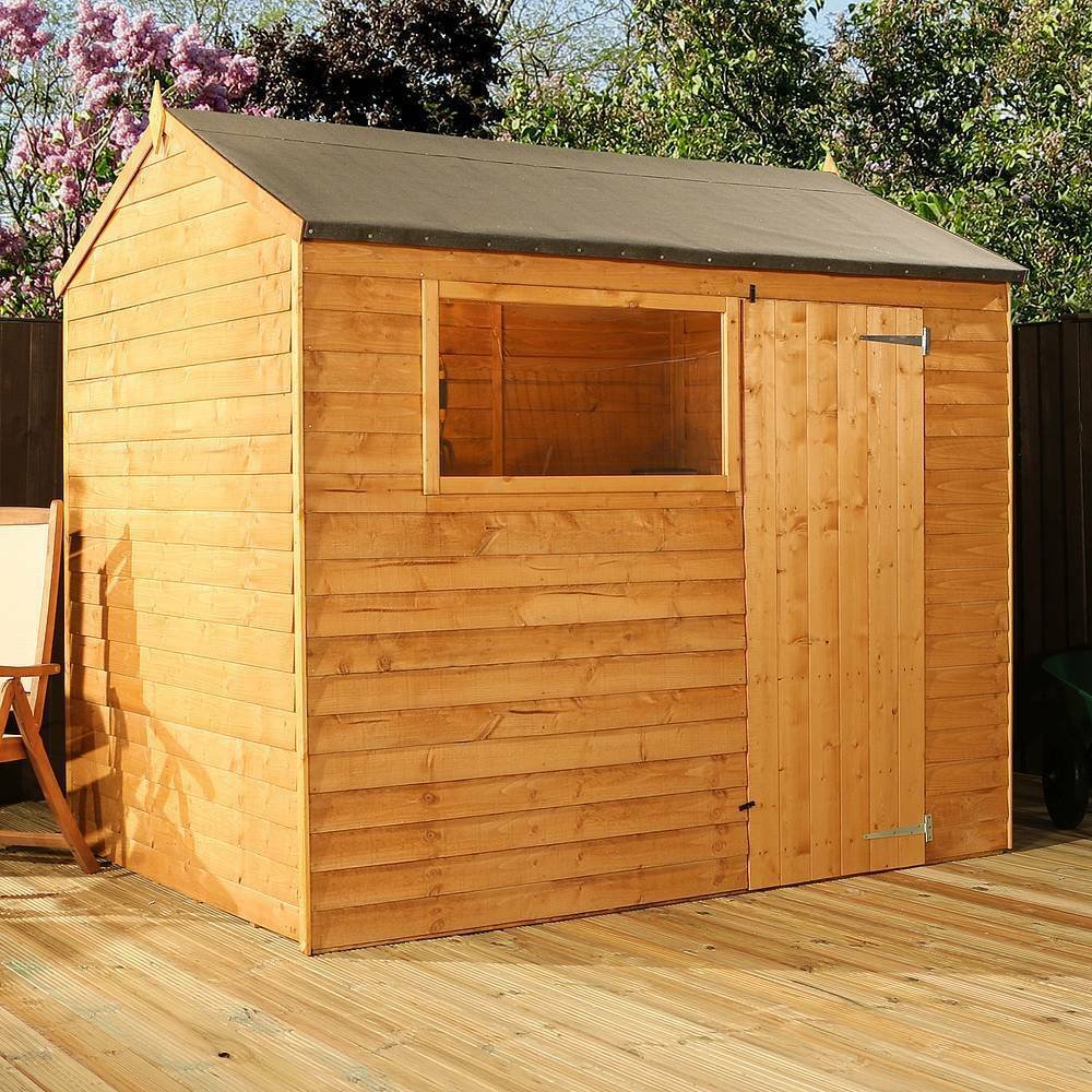 Wooden garden shed on a deck, surrounded by trees and flowers.