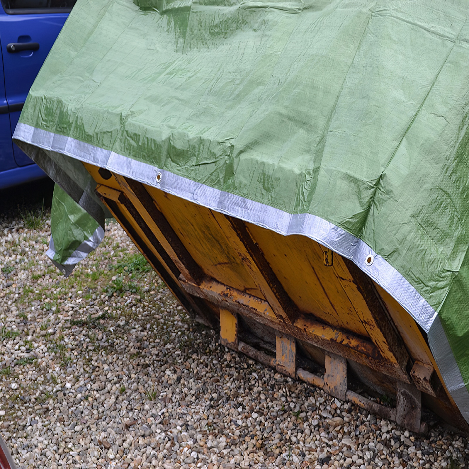 Green and silver reversible tarpaulin with eyelets, measuring 12ft by 9ft covering-skip