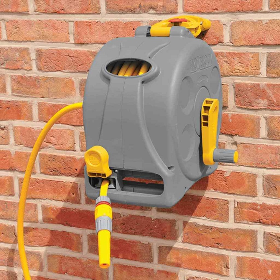 Hozelock hose pipe reel mounted on a brick wall with yellow hose attached.