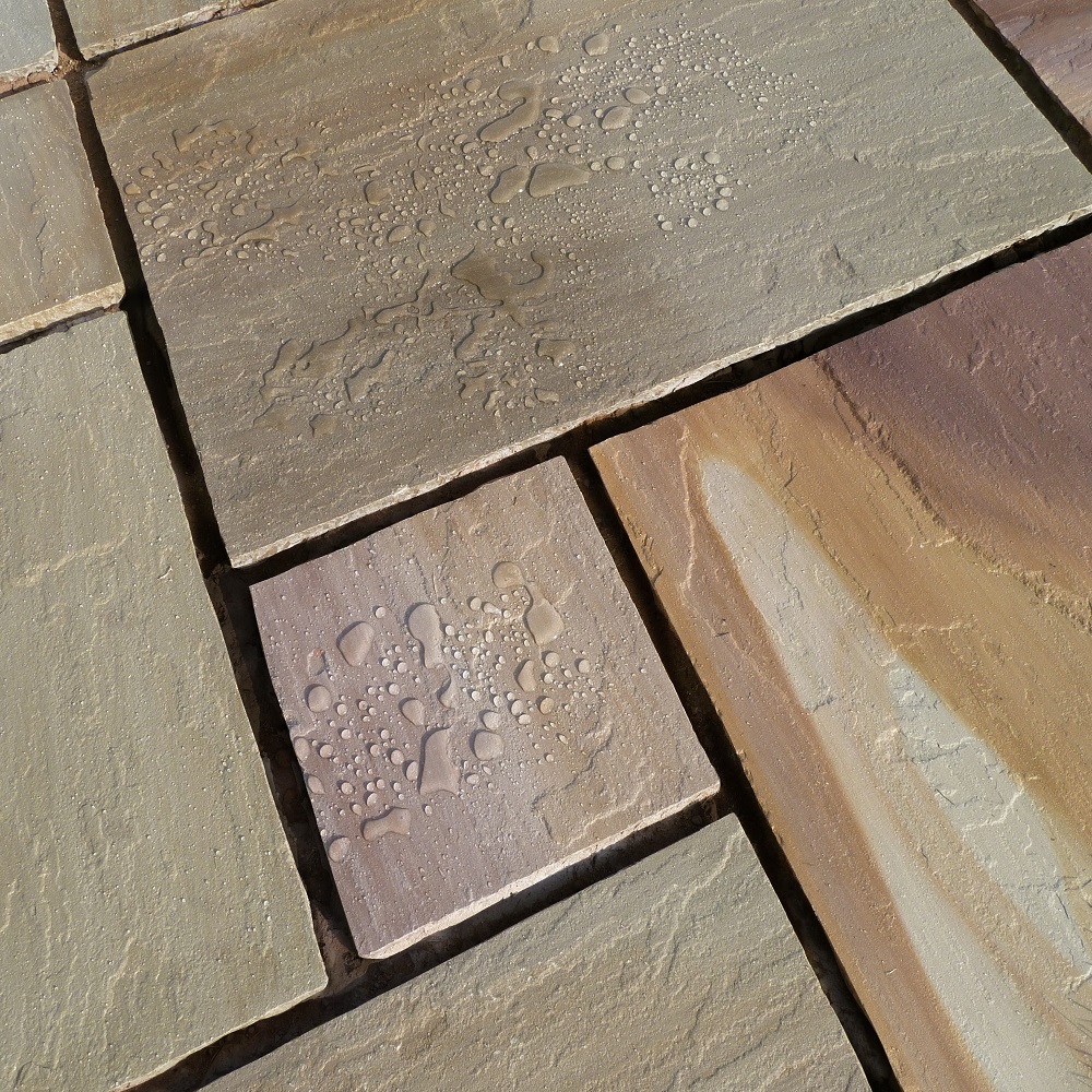 Natural stone tiles with water droplets highlighting a sealed surface.