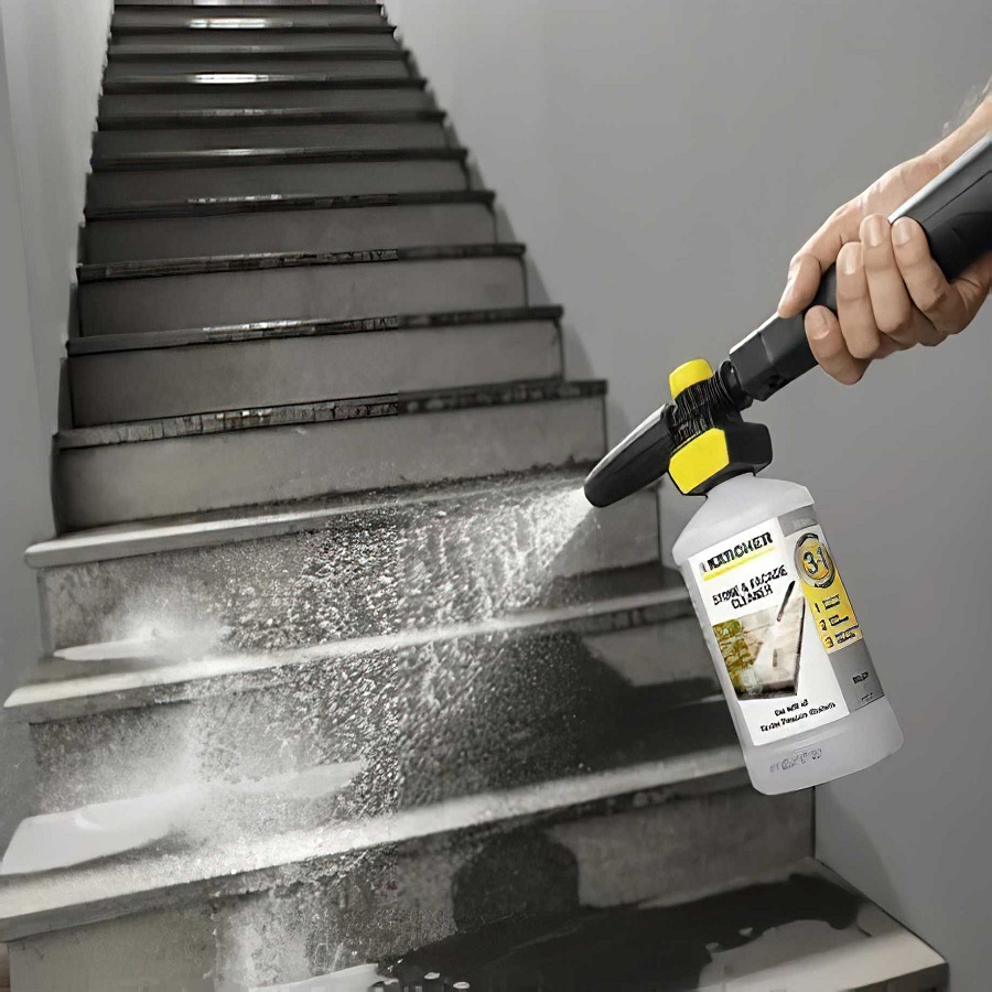 Person using Karcher Stone Path, Patio and Facade Cleaner Liquid Concentrate on outdoor steps.