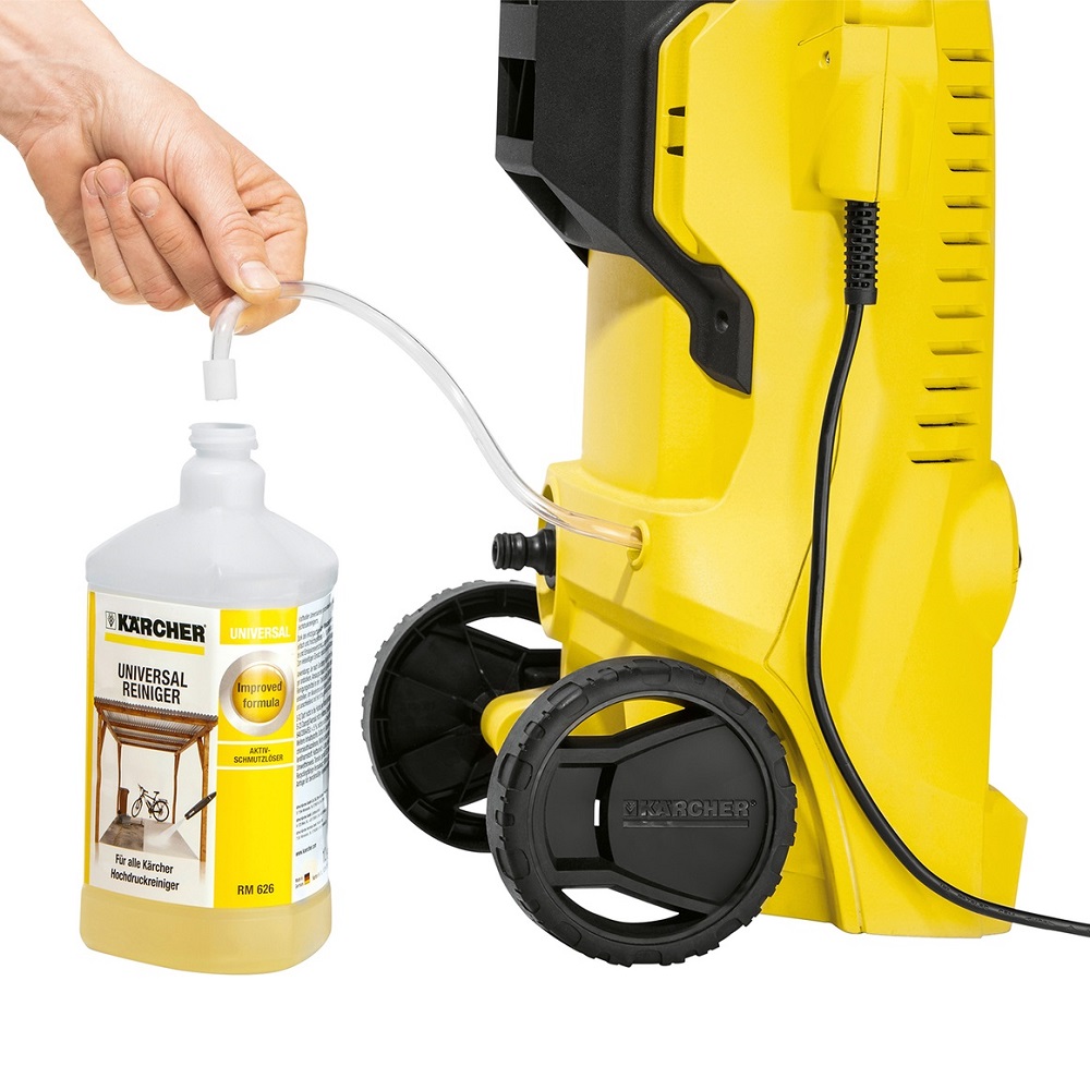 Hand connecting a bottle of Karcher Universal Pressure Washer Cleaner Concentrate to a yellow pressure washer.