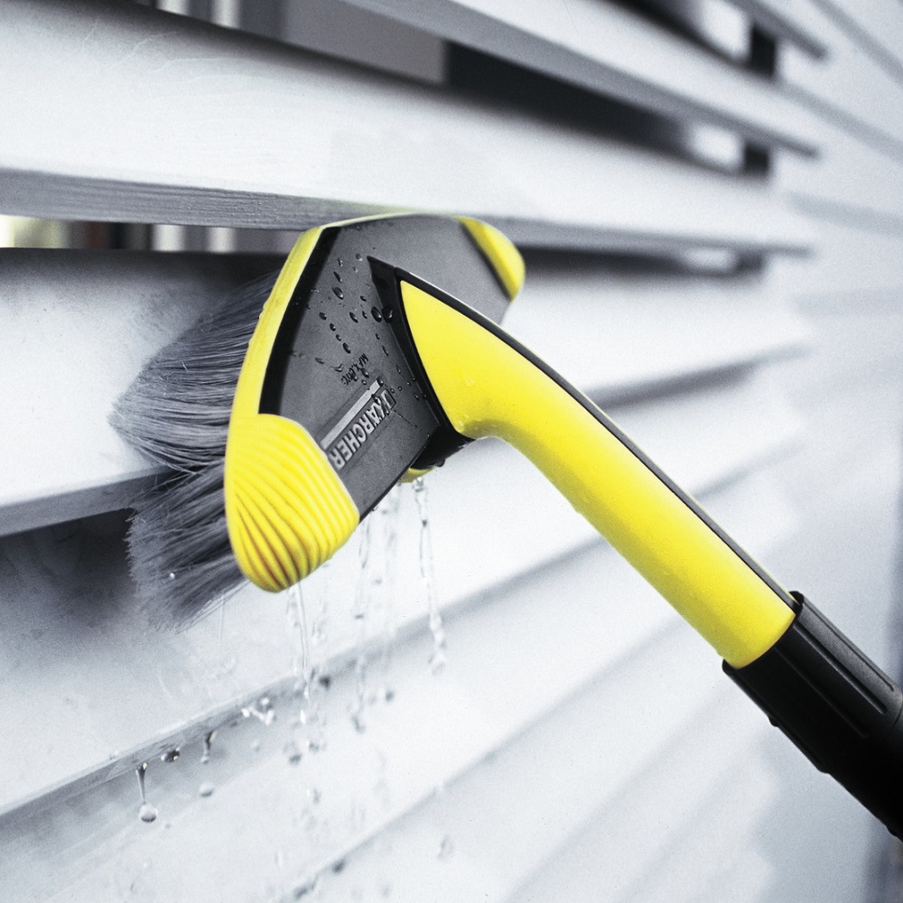 Karcher soft brush pressure washer gently cleaning a white surface with water flowing.