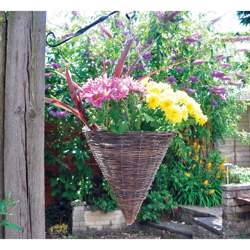 A 12 inch dark rattan willow wicker round hanging flower basket filled with colourful flowers in a garden setting.
