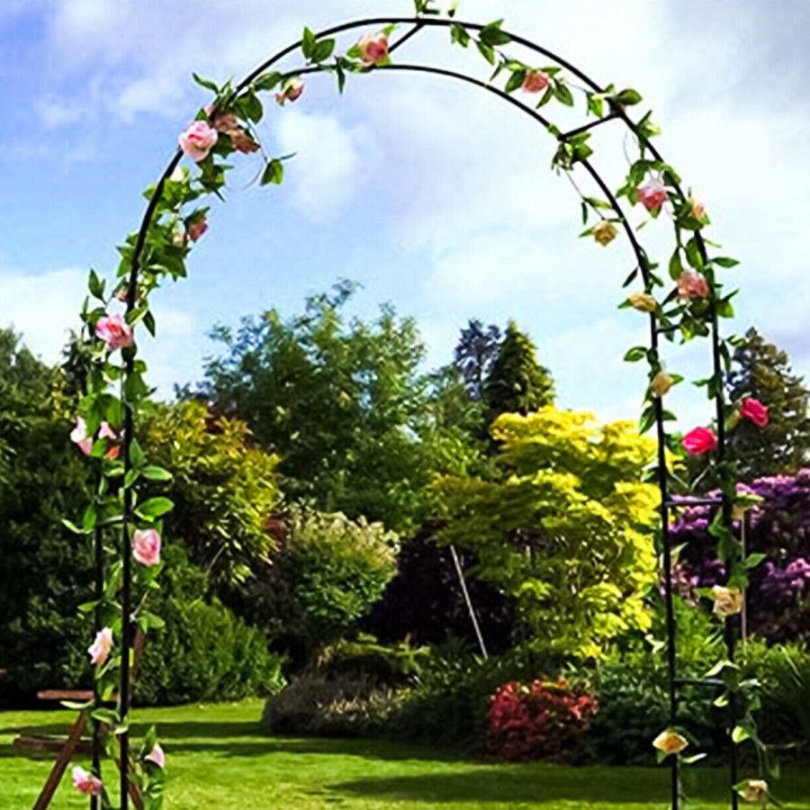 Metal garden archway with climbing plants and flowers in a lush garden setting.
