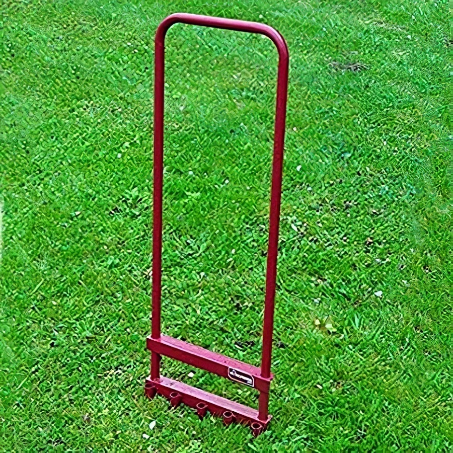 Red 5 prong lawn aerator on green grass