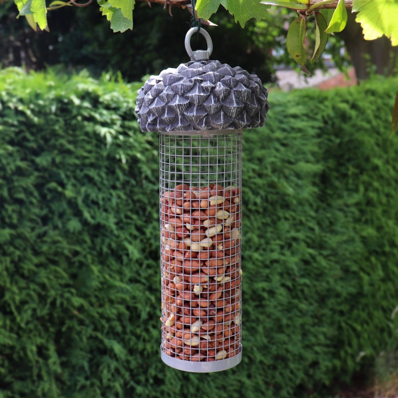 Acorn-shaped wild bird nut feeder hanging in a garden.