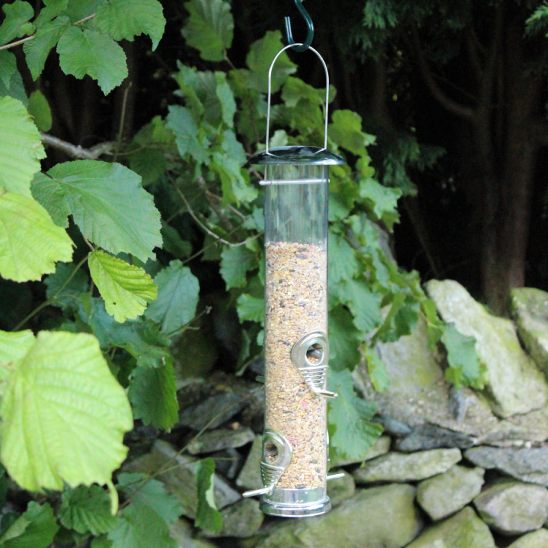 Bird feeder filled with Natures Market Wild Bird Food Robin Seed and Insect Mix hanging in a garden.