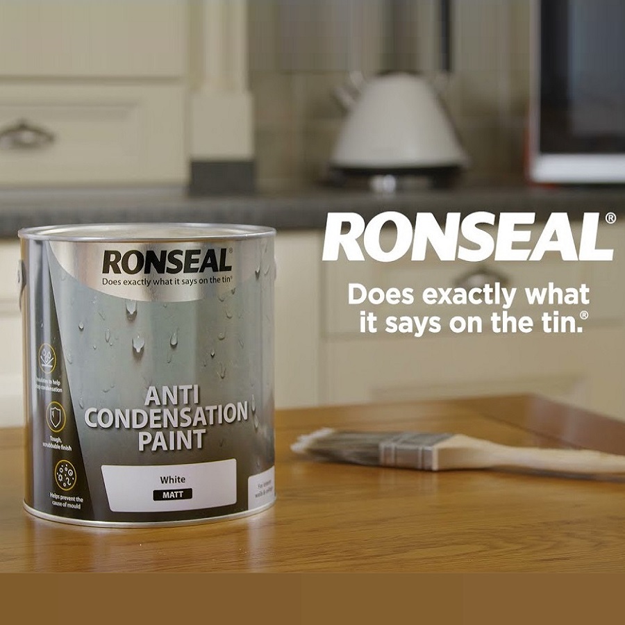 Ronseal Anti-Condensation Paint White Matt 750ml tin on a kitchen counter with a paintbrush beside it.