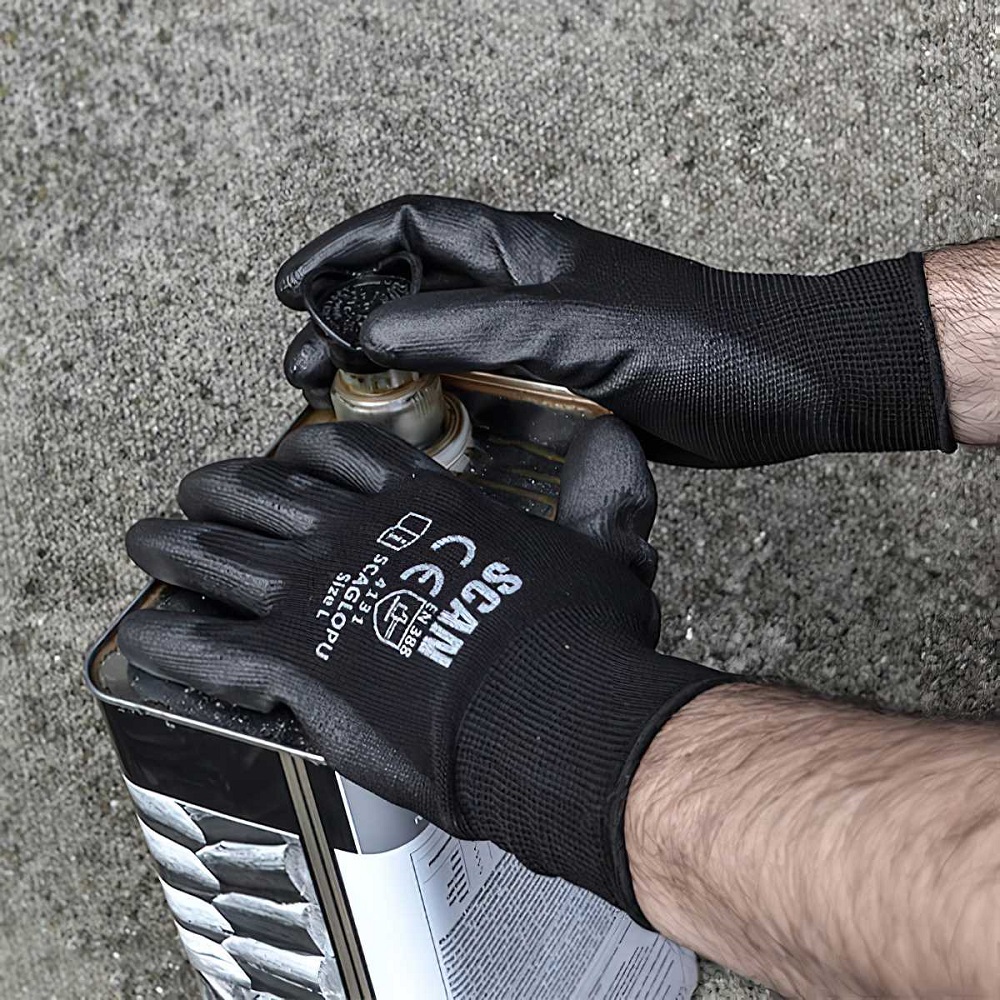 Person wearing black Scan PU Poly Palm Work Gloves handling a container.