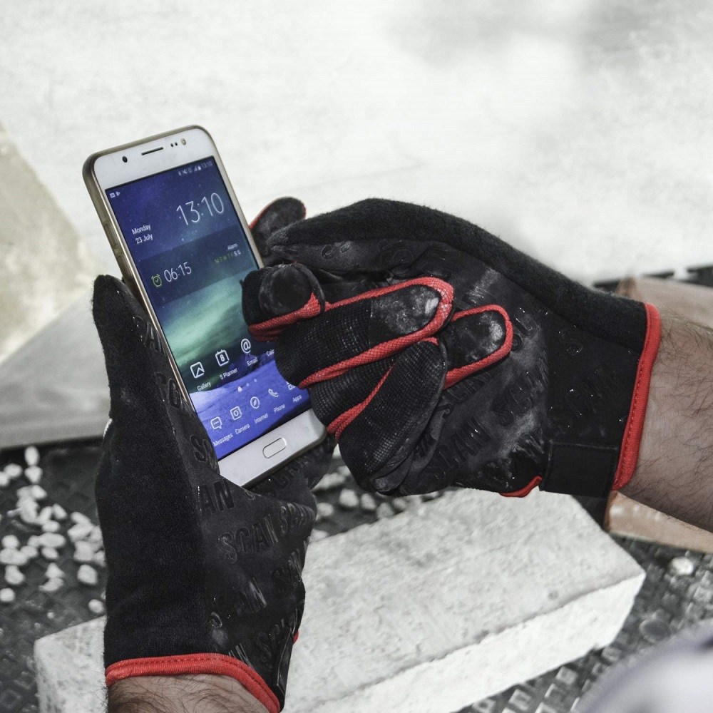 Person wearing Scan Grip Work Gloves Large using a smartphone.