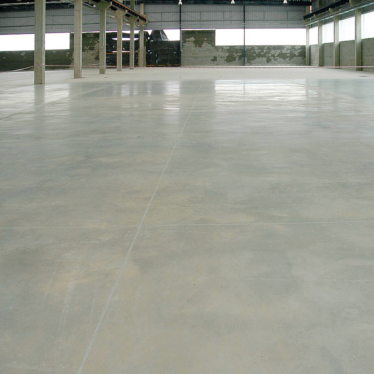 Smooth concrete surface in a large industrial space.