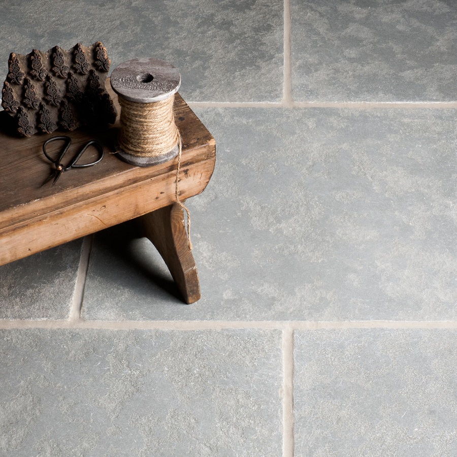 Natural stone flooring with a wooden table, spool of twine, and scissors.