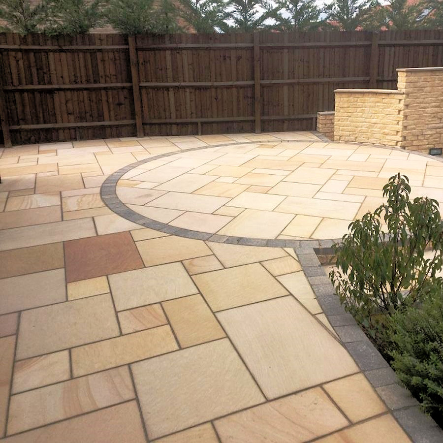 Patio with natural stone paving and a circular design.