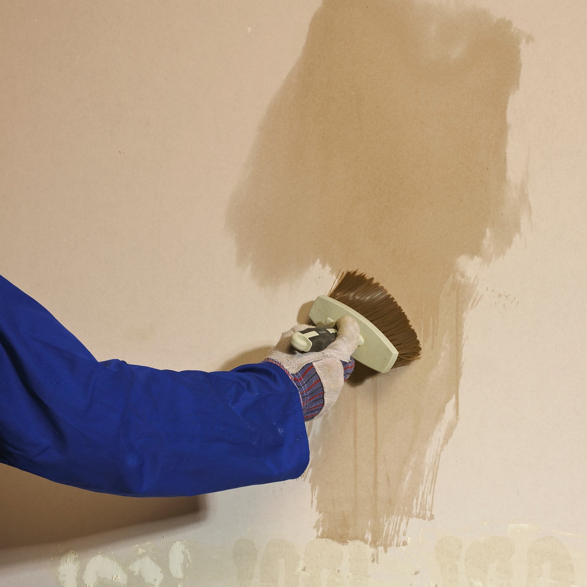 Person applying Sika Sikabond PVA+ on a wall with a brush