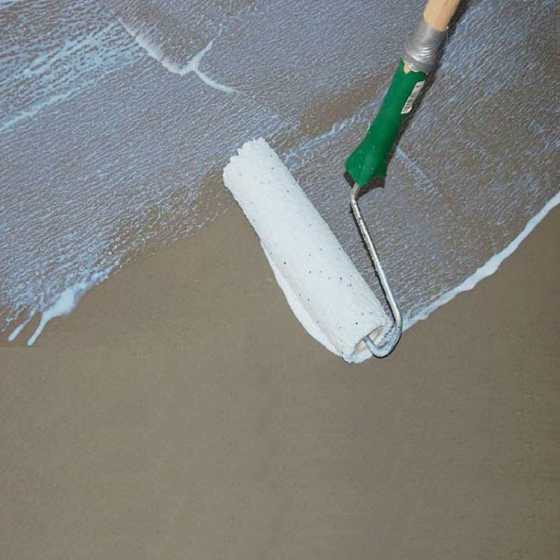 Close-up of a paint roller applying SikaBond SBR+ bonding agent on a concrete surface.