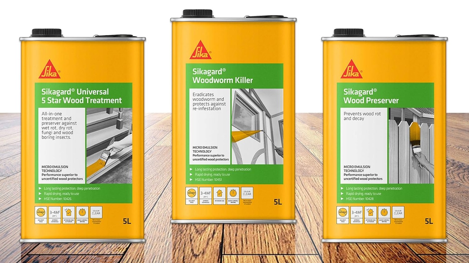 Three yellow cans of Sika wood treatment products on a wooden floor.
