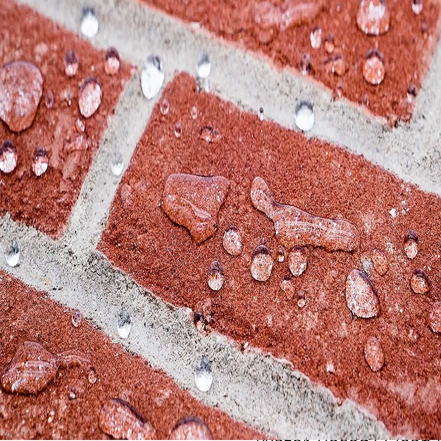 Close-up of water droplets on a brick surface treated with a waterproofing solution.