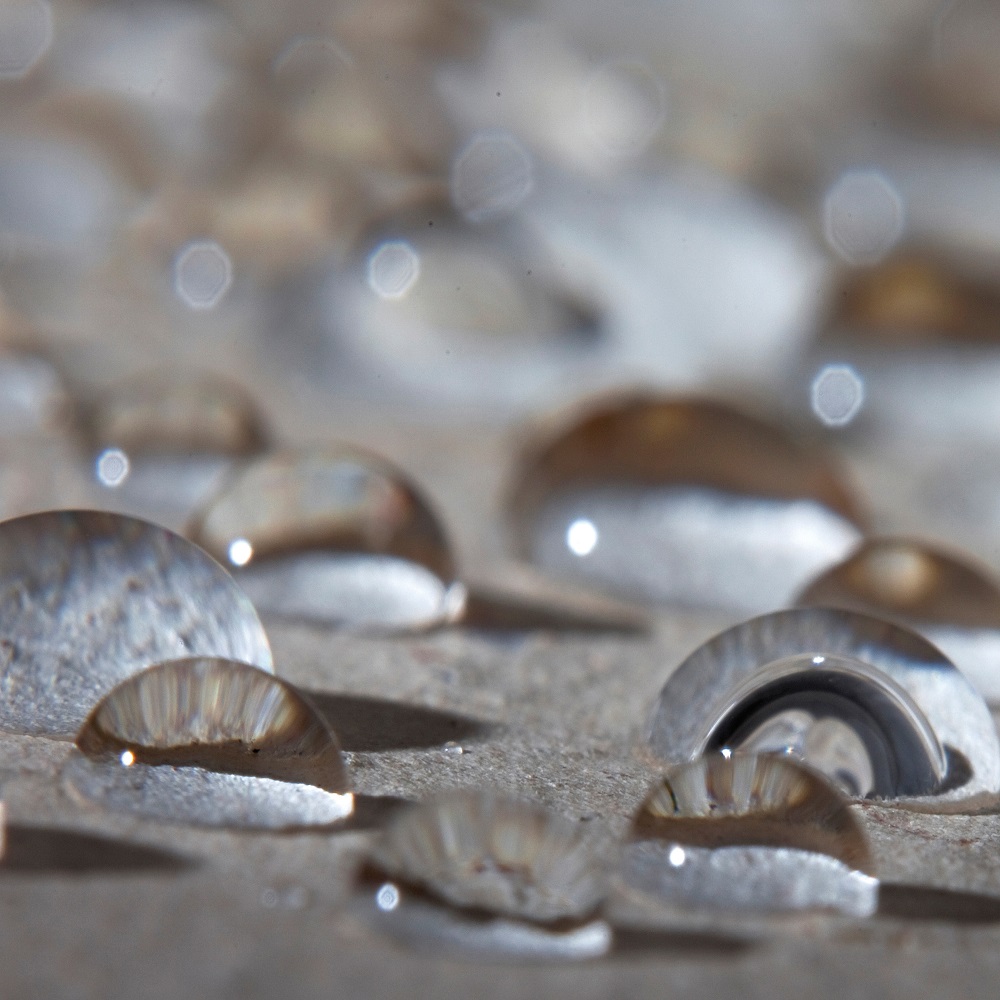 Close-up of water droplets on a surface, showcasing the repellent effect.