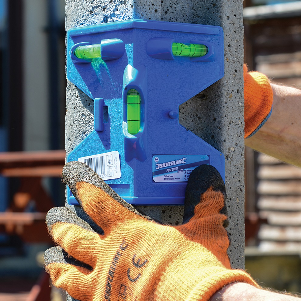 Person using a Silverline 3 vial fence post and timber level on a concrete post.