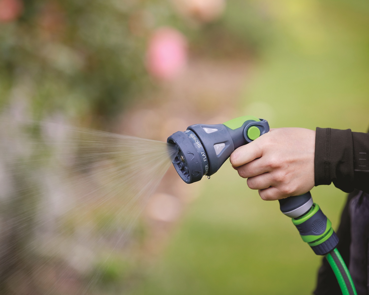 Green and grey garden hose spray water gun with connectors full water spray pattern