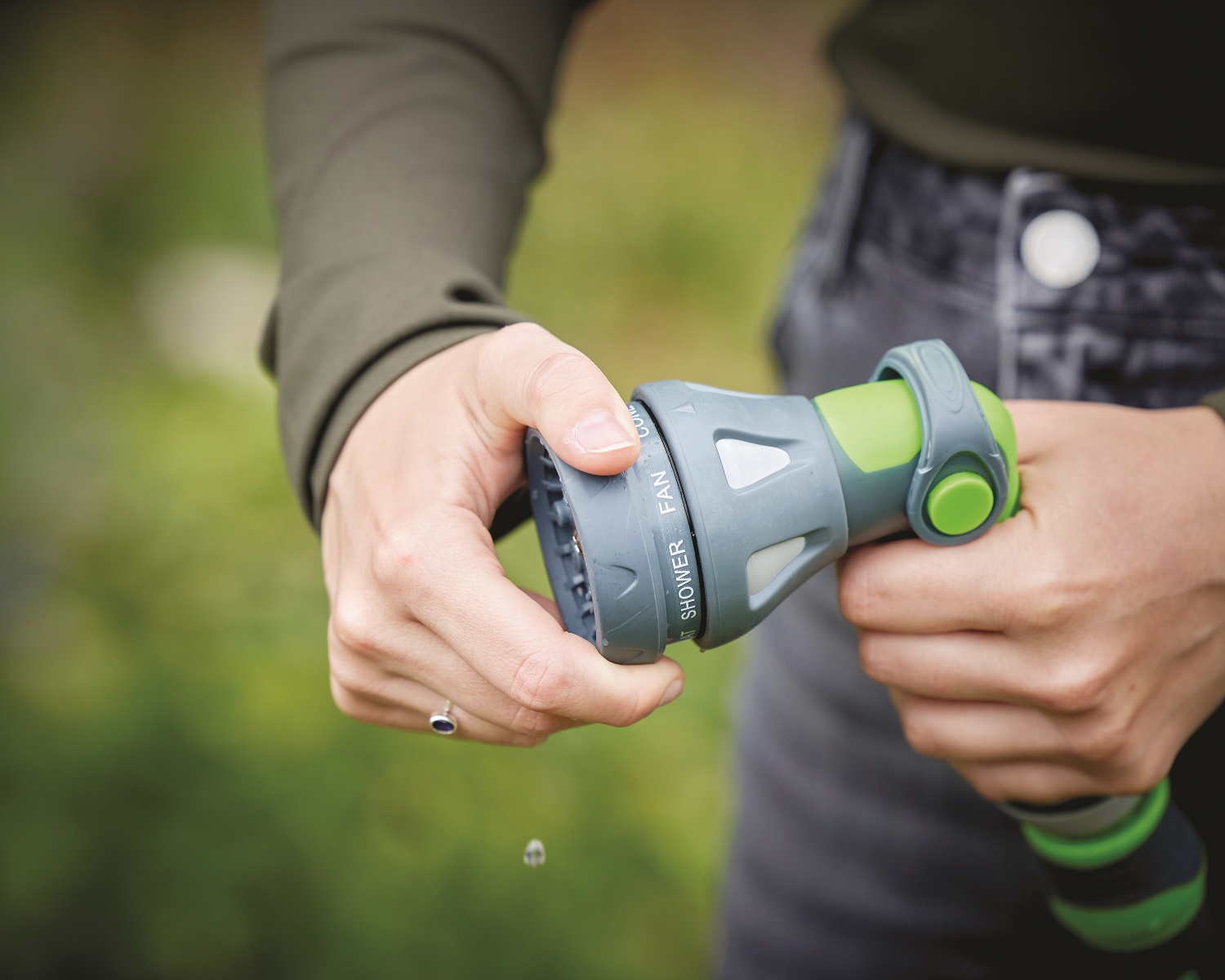 Green and grey garden hose spray water gun with connectors adjusting spray pattern