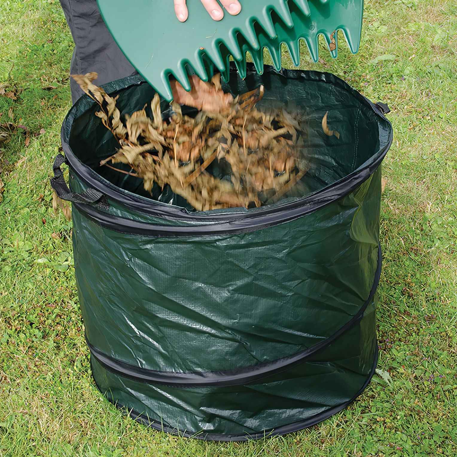 Green garden refuse sack with leaves being collected.