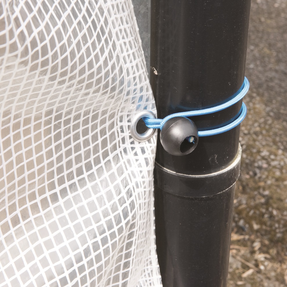 Close-up of a transparent tarpaulin secured with a blue bungee cord to a black pole.