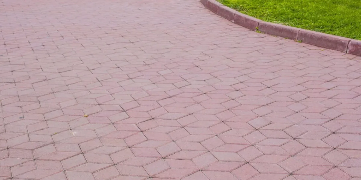 Geometric paving design next to lawn Hexagonal patterned pavement with adjacent green grass